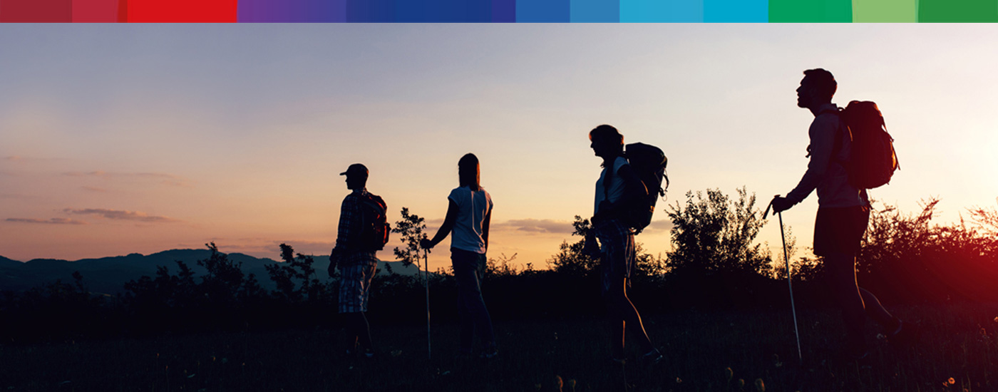 silhouette of four adult hikers watching sunset